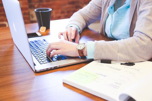 Person tippt auf Tastatur eines Laptops