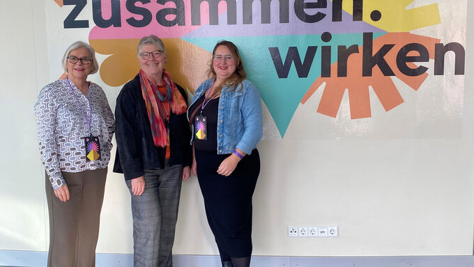 Drei Frauen vor dem Veranstaltungsbanner