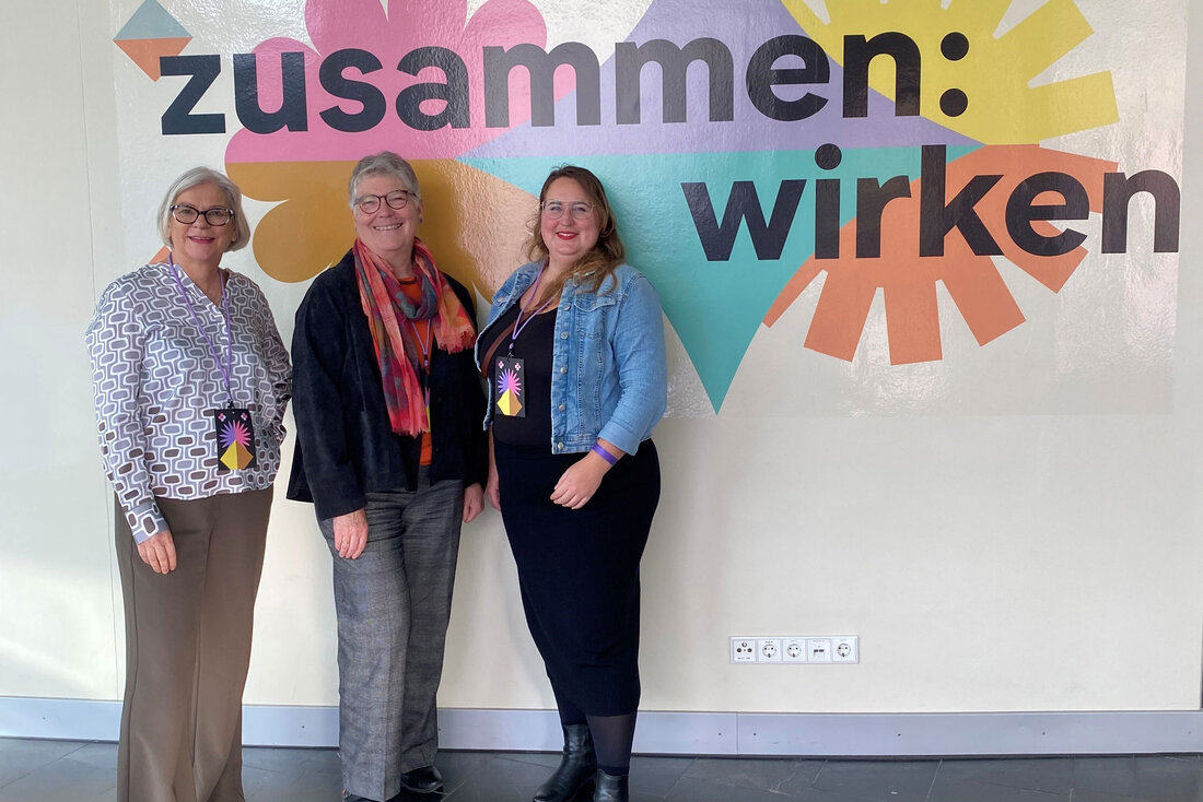 Drei Frauen vor dem Veranstaltungsbanner