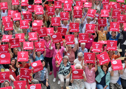 kfd-Frauen halten Sitzkissen hoch