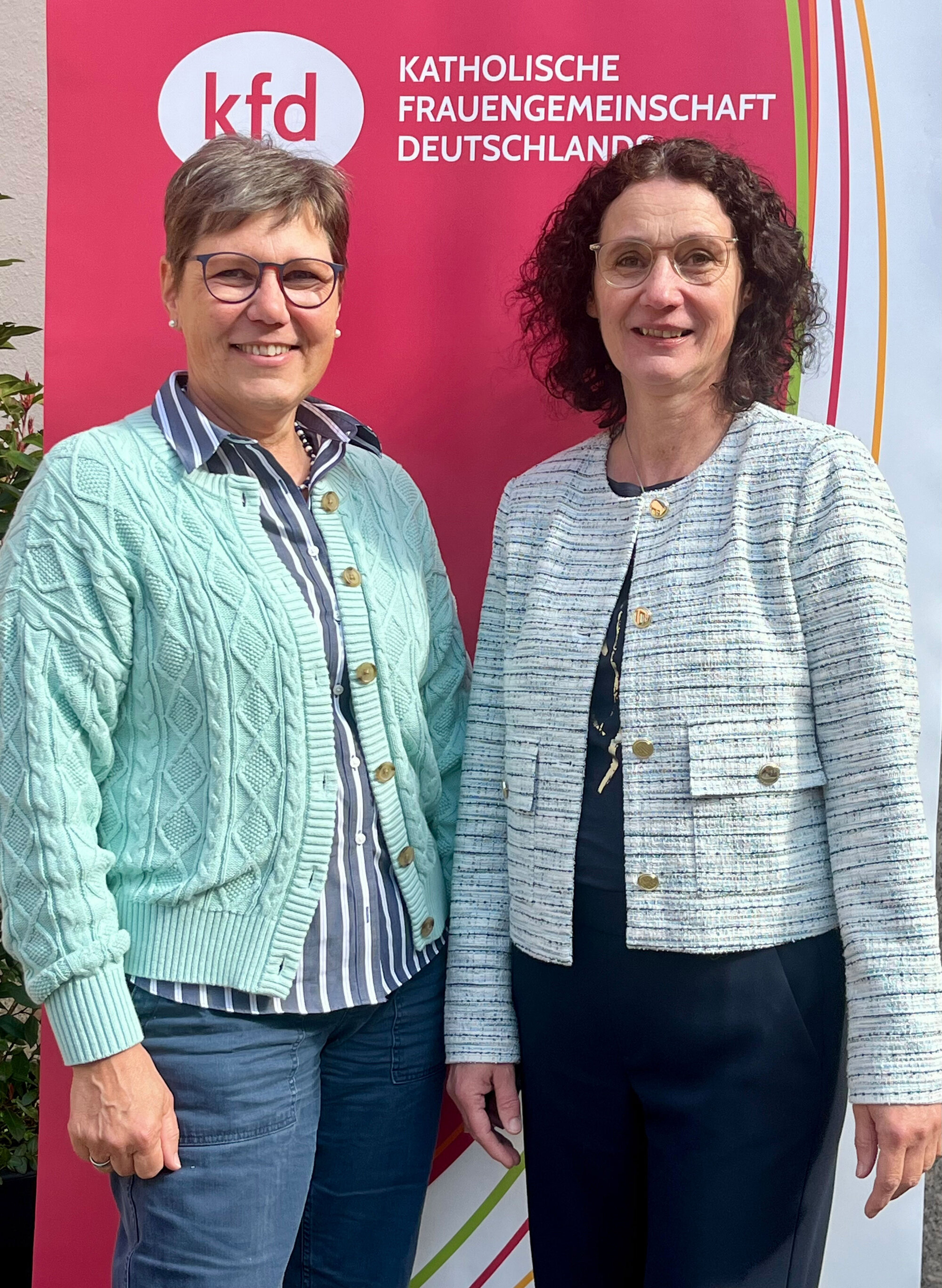 Zwei Frauen stehen vor einem kfd-Rollup